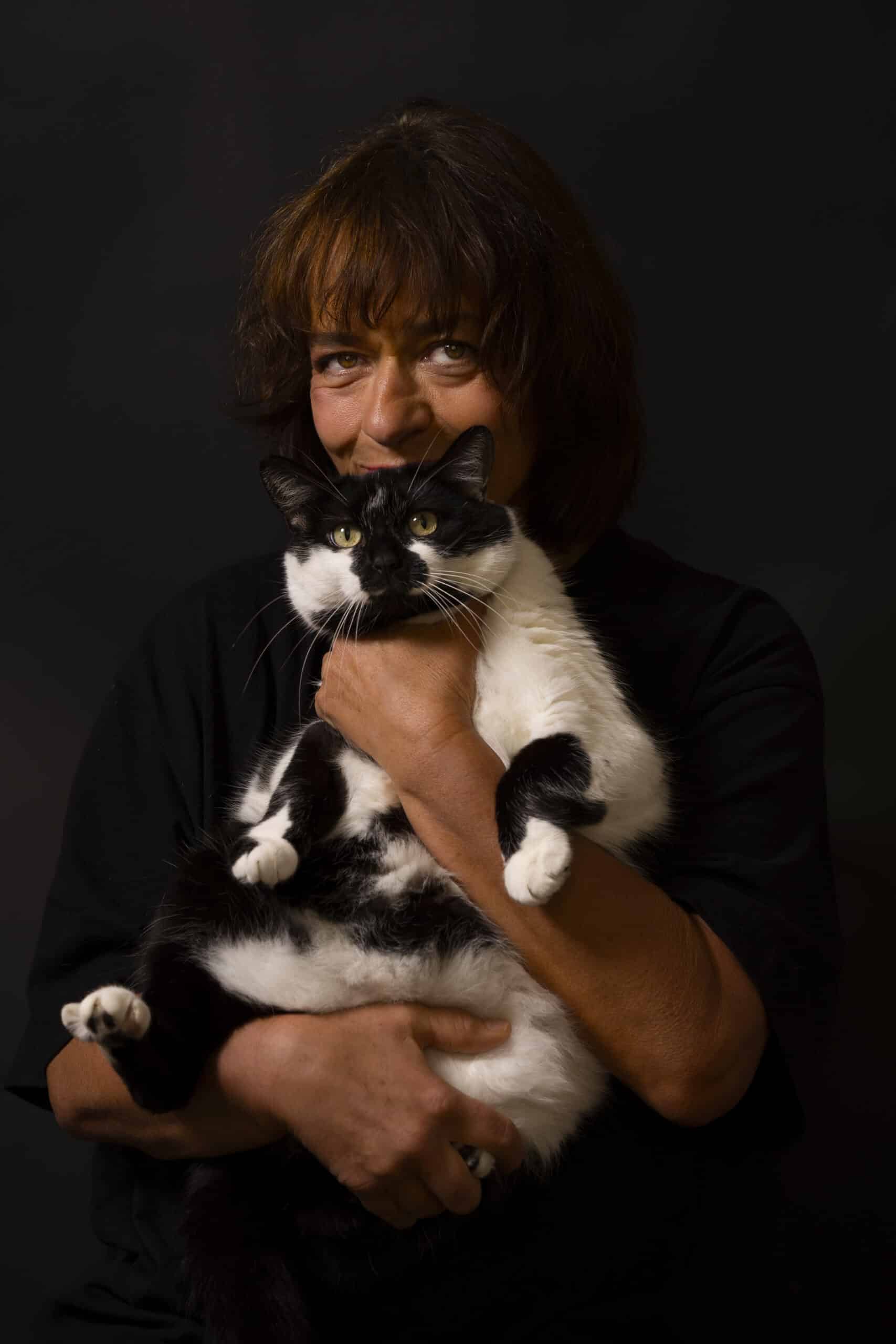 Portrait studio fond noir avec femme et chat